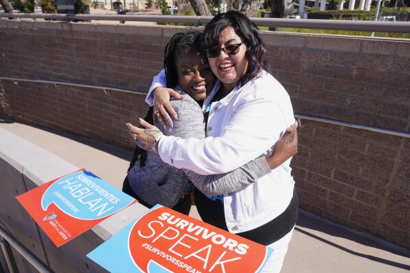 Vanessa Martinez, right, smiles as she gets a hug from Celina Meadows, left, head of the Arizona chapter of Crime Survivors for Safety and Justice, at a Survivors Speak rally at the Arizona Capitol, Monday, Feb. 27, 2023, in Phoenix. Despite still recovering or dealing with the aftermath of being the victims of violent crime, many survivors are telling their stories to try to change the victim compensation programs in their states. (AP Photo/Ross D. Franklin)