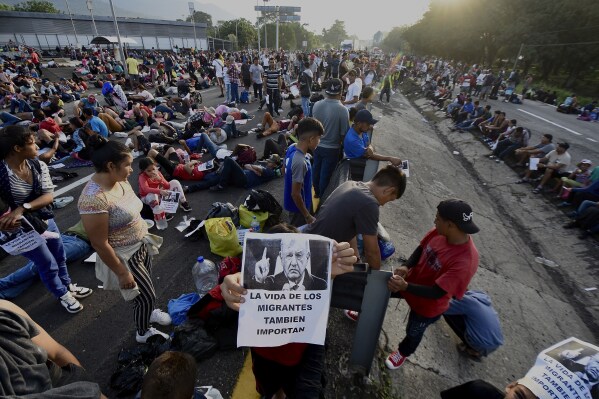 A migrant holds a photo of Mexican President Andrés Manuel López Obrador that reads in Spanish: 