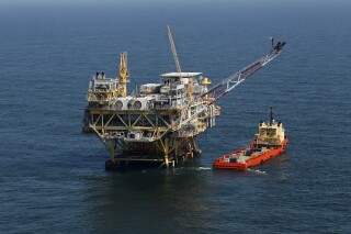 FILE - A rig and supply vessel are pictured in the Gulf of Mexico off the cost of Louisiana, April 10, 2011. A federal judge has ordered the Interior Department to expand next week’s scheduled sale of Gulf of Mexico oil and gas leases by millions of acres. The Thursday, Sept. 22, 2023, ruling rejected a scaled-back plan announced last month by the Biden administration as part of an effort to protect an endangered whale species. (AP Photo/Gerald Herbert, File)