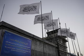 FILE - Taliban flags fly at the airport in Kabul, Afghanistan, Sept. 9, 2021. Two years on from the Taliban takeover of Afghanistan, the United States has begun easing rules that could allow commercial airlines to fly over the country in routes that cuts time and burned fuel for East-West travel. But those flights shortening routes for India and Southeast Asia raise questions never answered during the Taliban's previous rule from the 1990s to the months after the Sept. 11, 2001, attacks. (AP Photo/Bernat Armangue, File)
