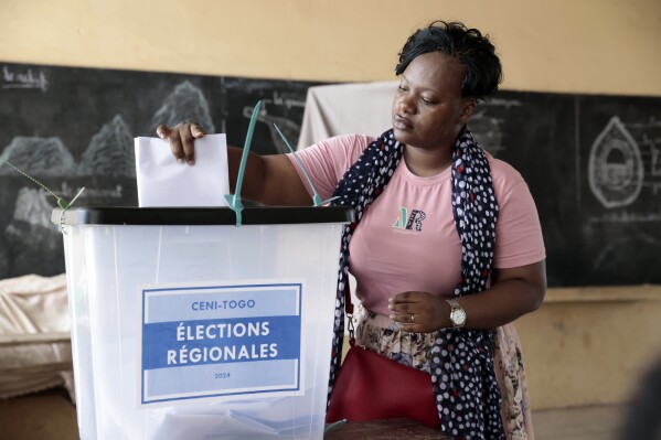 A voter casts her ballot in Togo's regional elections in the capital Lome, Monday April 29, 2024. Togolese voters headed to the polls on Monday to vote in the country's parliamentary elections, which will test support for a proposed new constitution that would scrap future presidential elections and give lawmakers the power to choose the president instead. (AP Photo/Erick Kaglan}
