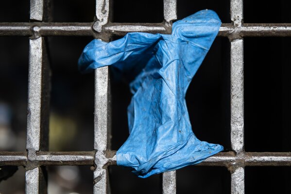 This Monday, May 25, 2020 photo shows a discarded glove on a storm drain in Philadelphia. Between mid-March, when the city’s stay-at-home order was issued, and the end of April, most of the 19 sewe...