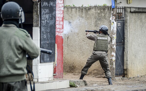 A police officer aims his weapon at protesters in Maputo, Mozambique, Thursday, Nov. 7, 2024. Protesters dispute the outcome of the Oct. 9 elections that saw the ruling Frelimo party extend its 49-year rule. (AP Photo/Carlos Uqueio, File)