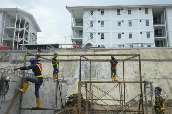 Workers build a metal structure at the construction site of the new capital city in Penajam Paser Utara, East Kalimantan, Indonesia, Wednesday, March 8, 2023. Officials promise a "sustainable forest city" that puts the environment at the heart of the development and aims to be carbon-neutral by 2045. But the project has been plagued by criticism from environmentalists and Indigenous communities, who say it degrades the environment, further shrinks the habitat of endangered animals such as orangutans and displaces Indigenous communities that rely on the land for their livelihoods. (AP Photo/Achmad Ibrahim)