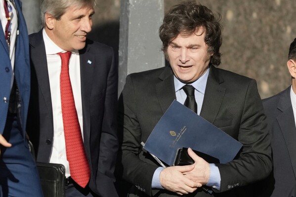 Argentine President Javier Milei, right, and his Economy Minister Luis Caputo enter the Economy Ministry after a meeting with US Treasury Secretary Scott Bessent in Buenos Aires, Argentina, Monday, April 14, 2025. (AP Photo/Natacha Pisarenko)
