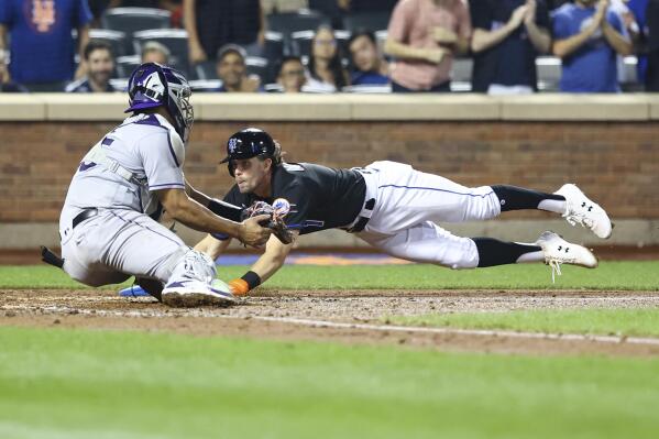 Colorado Rockies relief pitcher Daniel Bard left fielder Connor Joe (9) and  catcher Elias Diaz at the end of a baseball game against the Chicago Cubs  in Chicago, Sunday, Sept. 18, 2022. (