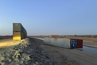 This photo provided of Univision Arizona shows empty shipping containers toppled over Sunday overnight on the Mexico-US international borderline in Yuma, Ariz., on Monday, Aug. 16, 2022. An effort by Arizona's Republican Gov. Doug Ducey to use shipping containers to close a 1,000-foot gap in the U.S.-Mexico border wall suffered a temporary setback over the weekend when two containers stacked on top of each were somehow toppled over. The stacked pair of containers were righted by early Monday morning. (Claudia Ramos/Univision Arizona via AP)