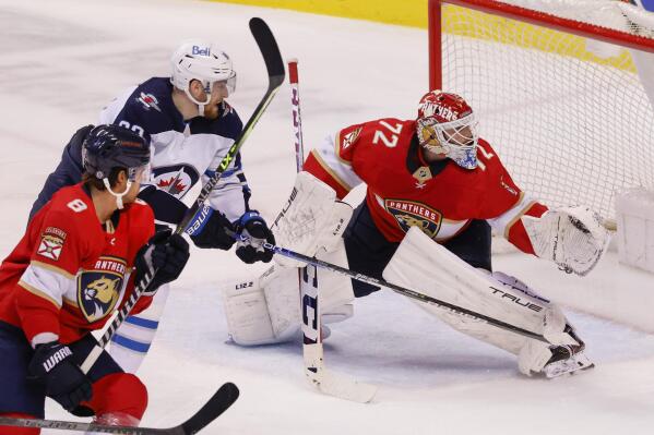 Florida Panthers goaltender Sergei Bobrovsky (72) kicks aside a shot by Winnipeg Jets left wing Pierre-Luc Dubois (80) as Panthers defenseman Ben Chiarot (8) skates in during the third period of an NHL hockey game Friday, April 15, 2022, in Sunrise, Fla. (AP Photo/Reinhold Matay)