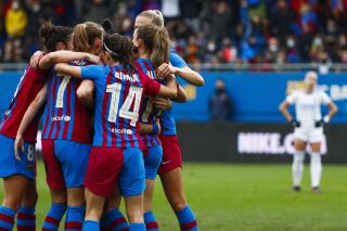 FILE - Barcelona players celebrate after teammate Alexia Putellas scored a goal during the Women's Spanish La Liga soccer match between Barcelona and Real Madrid at Johan Cruyff stadium in Barcelona, Spain, Sunday, March 13, 2022. The start of Spain’s new professional women’s league has been called off after referees refused to work until their demands for better wages and work conditions are met. The league was scheduled to kick off on Saturday, Sept. 10, 2022 but the league issued a statement saying that it was impossible to hold the games after the referee crews did not show up. Spain’s female soccer referees announced a strike on Thursday. (AP Photo/Joan Monfort, File)