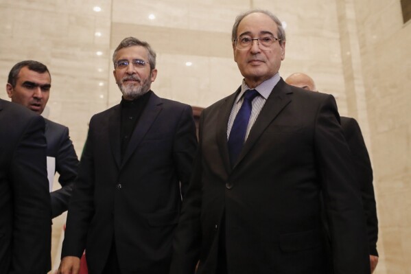 Syrian Foreign Minister Faisal Mekdad, right, arrives with Iranian interim Foreign Minister Ali Bagheri Kani, center, for their press conference in Damascus, Syria, Tuesday, June 4, 2024. Mekdad said Tuesday that any dialogue between Syria and Turkey should be preceded by Ankara's announcement that it will withdraw its troops from all Syrian territories that it controls. (AP Photo/Omar Sanadiki)