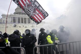 FILE - In this Jan. 6, 2021, U.S. Capitol Police officers hold off rioters loyal to President Donald Trump at the Capitol in Washington. (AP Photo/Julio Cortez, File)
