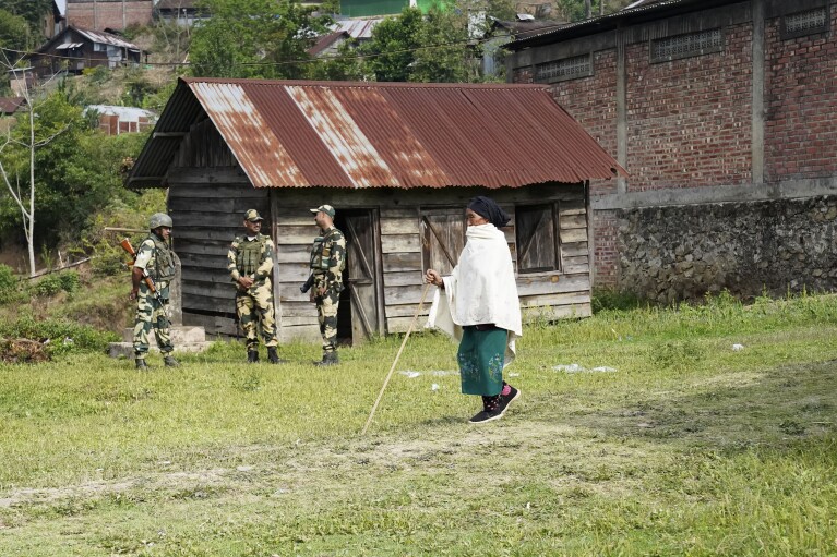 An elderly woman arrives at a polling station to cast her vote in Shangshak village, in the northeastern Indian state of Manipur, Friday, April 26, 2024. (AP Photo/Yirmiyan Arthur)