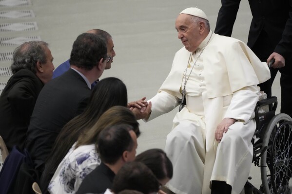 Pope Francis greets Bassan Aramin, left, and Rami Elhanan during the weekly general audience at the Vatican, Wednesday, March 27, 2024. (AP Photo/Gregorio Borgia)