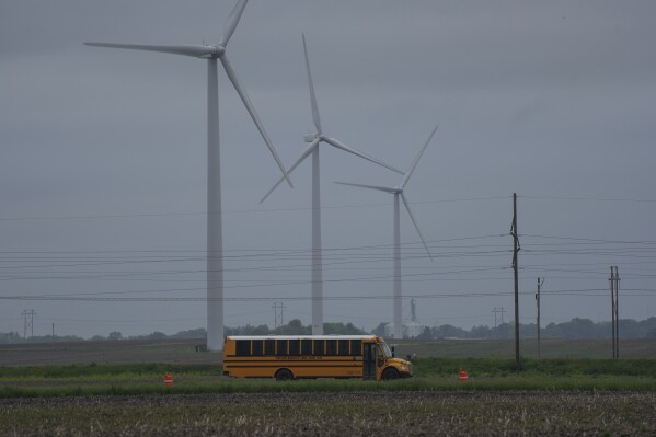 A school bus drives down a road near a field of wind turbines, Thursday, May 9, 2024, in Paxton, Ill. (ĢӰԺ Photo/Joshua A. Bickel)