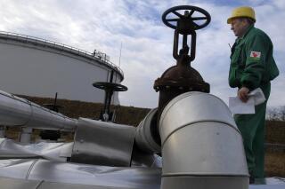 FILE - Istvan Szekeres, engineer of the Hungarian Oil and Gas Company (MOL) checks the receiving area of the Druzhba oil pipeline in the country's largest oil refinery in Szazhalombata, south of Budapest, Hungary, Jan. 9, 2007. Several countries in Europe dependent on Russian energy suffered another blow with confirmation Tuesday, Aug. 9, 2022 that oil shipments have stopped through a critical pipeline. Russian state pipeline operator Transneft said it halted shipments through the southern branch of the Druzhba oil pipeline, which flows through Ukraine to the Czech Republic, Slovakia and Hungary. (AP Photo/Bela Szandelszky, File)