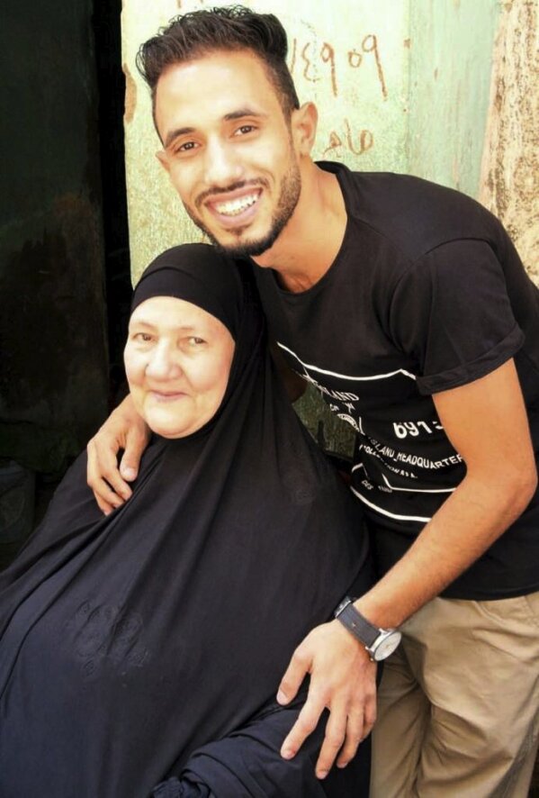 This undated handout image provided by the family of El-Sayed, shows Ghaliya Abdel-Wahab, who died from COVID-19 on April 6, 2020, poses for a photograph with her grandson, in Shubra el-Kheima neighborhood, Qalyoubiya governorate, Egypt. The novel coronavirus struck her family with horrific speed, infecting 45 of her relatives. (El-Sayed family via AP)