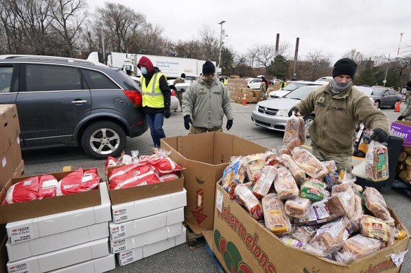 FILE - Sgt. Kevin Fowler organizes food at a food bank distribution by the Greater Cleveland Food Bank, Thursday, Jan. 7, 2021, in Cleveland. Supporting nonprofits on GivingTuesday this year could have a bigger impact than usual as nonprofits and industry groups say donations so far are down compared with previous years. Many organizations will be looking to make up the difference on GivingTuesday, which is the Tuesday after Thanksgiving, Nov. 28, 2023. (AP Photo/Tony Dejak File)