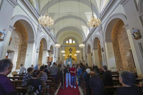 Faithful follow a traditional procession on the Feast Day of St. George in St. George Church in the Maronite village of Kormakitis in the breakaway north of the ethnically divided Cyprus on Wednesday, April 23, 2025. (AP Photo/Petros Karadjias)