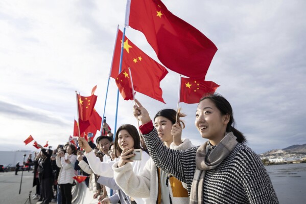 In this photo released by Xinhua News Agency, people wave Chinese flags to welcome Chinese President Xi Jinping in San Francisco, Tuesday, Nov. 14, 2023. Ahead of the highly anticipated meeting on Wednesday between U.S. President Joe Biden and Chinese leader Xi Jinping, Chinese state media have taken a new tone toward the U.S. with less negative coverage, calls for a return to warmer ties and stories of Americans with positive connections to the country. (Liu Jie/Xinhua via AP)