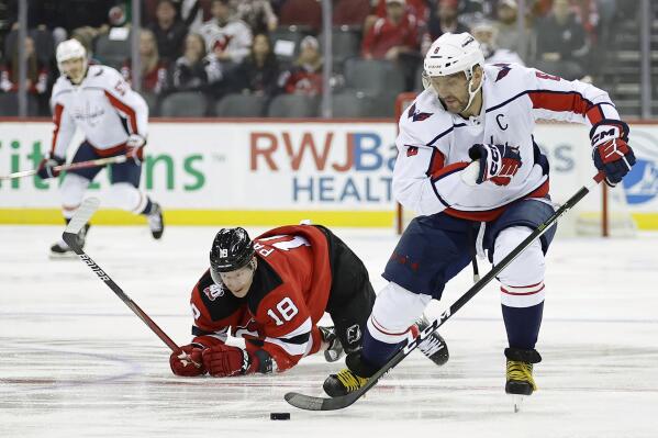 Washington Capitals left wing Alex Ovechkin skates with the puck past New Jersey Devils left wing Ondrej Palat (18) in the first period of an NHL hockey game Monday, Oct. 24, 2022, in Newark, N.J. (AP Photo/Adam Hunger)