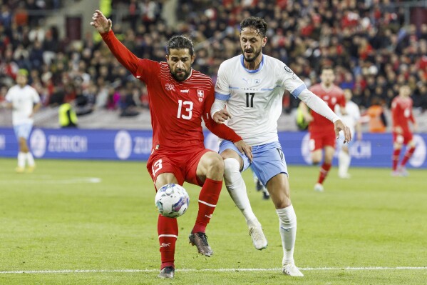 FILE - Switzerland's defender Ricardo Rodriguez, left, fight for the ball with Israel's midfielder Sagiv Jehezkel during the Euro 2024 qualifying group I soccer match between Switzerland and Israel, at the Stade de Geneve, in Geneva, Switzerland, on March 28, 2023. Turkish authorities have detained soccer club Antalyaspor’s Israeli player Sagiv Jehezkel for questioning after he displayed solidarity with people held hostage by the Hamas militant organization during a top-flight league game. (Salvatore Di Nolfi/Keystone via AP, File)