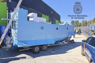 In this photo provided by the Spanish National police on Friday March 12, 2021, a homemade semi submersible submarine sits outside a warehouse in Malaga, Spain. Spanish police say they have seized a homemade narco-submarine able to carry up to 2 metric tons (2.2 tons) of cargo. Police came across the 9-meter-long (30-feet-long) craft being built in Málaga, on southern Spain’s Costa del Sol, during a broader international drug operation. Police said Friday it has two 200-horsepower engines, which are operated from the inside. (Police Nacional via AP)