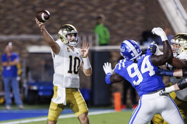 Notre Dame's Sam Hartman (10) makes a throw over Duke's R.J. Oben (94) during the first half of an NCAA college football game in Durham, N.C., Saturday, Sept. 30, 2023. (AP Photo/Ben McKeown)