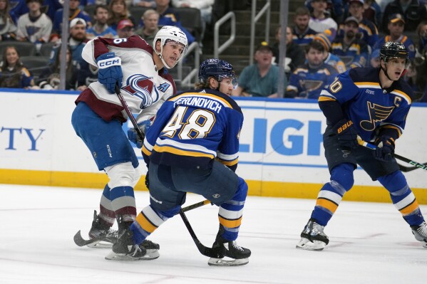 Colorado Avalanche's Mikko Rantanen, left, scores past St. Louis Blues' Scott Perunovich (48) and Brayden Schenn (10) during the first period of an NHL hockey game Tuesday, March 19, 2024, in St. Louis. (AP Photo/Jeff Roberson)
