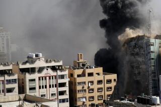 CORRECTS DATE TO MAY 15  A view of a 11-story building housing AP office and other media in Gaza City is seen moments after Israeli warplanes demolished it, Saturday, May 15, 2021.  The airstrike Saturday came roughly an hour after the Israeli military ordered people to evacuate the building. There was no immediate explanation for why the building was targeted. The building housed The Associated Press, Al-Jazeera and a number of offices and apartments.  (AP Photo/Hatem Moussa).