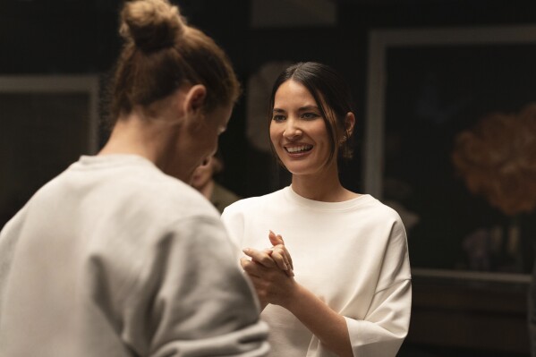 This image released by Apple TV+ shows Amanda Peet, left, and Olivia Munn in a scene from 