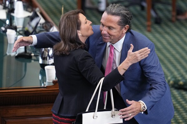 State Sen. Angela Paxton, R-McKinney, wife of suspended Texas state Attorney General Ken Paxton, left, embraces defense attorney Tony Buzbee, right, as they celebrate the acquittal of her husband in his impeachment trial in the Senate Chamber at the Texas Capitol, Saturday, Sept. 16, 2023, in Austin, Texas. (AP Photo/Eric Gay)