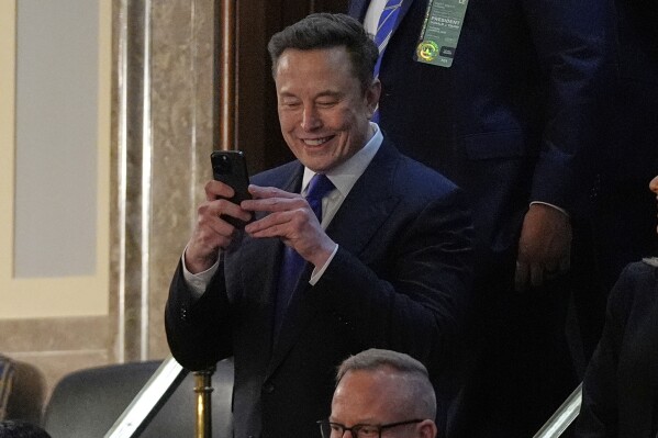 Elon Musk takes a photo as he arrives before President Donald Trump addresses a joint session of Congress in the House chamber at the U.S. Capitol in Washington, Tuesday, March 4, 2025. (AP Photo/Julia Demaree Nikhinson)