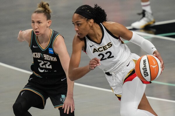 Las Vegas Aces' A'ja Wilson, right, drives past New York Liberty's Courtney Vandersloot during the first half in Game 4 of a WNBA basketball final playoff series Wednesday, Oct. 18, 2023, in New York. (AP Photo/Frank Franklin II)