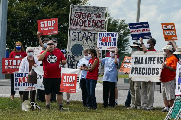 Protestors gather across from the the federal prison complex in Terre Haute, Ind., Friday, Aug. 28, 2020. Keith Dwayne Nelson, who was convicted of kidnapping, raping and murdering at 10-year-old Kansas girl, is schedule to be executed Friday. (AP Photo/Michael Conroy)
