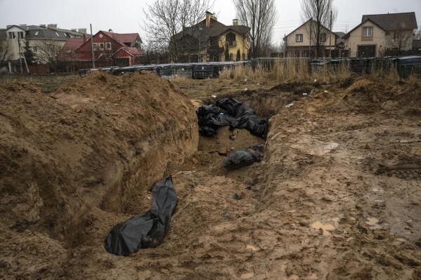 FILE - Bodies lie in a mass grave in Bucha, on the outskirts of Kyiv, Ukraine, Sunday, April 3, 2022. (AP Photo/Rodrigo Abd, File)