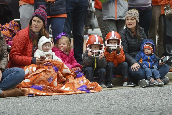 
              A family enjoys  the parade held in Clemson's honor Saturday, Jan. 12, 2019, in Clemson, S.C.,  TheTigers defeated Alabama 44-16 in the College Football Playoff championship game Monday Jan. 7. (AP Photo/Richard Shiro)
            