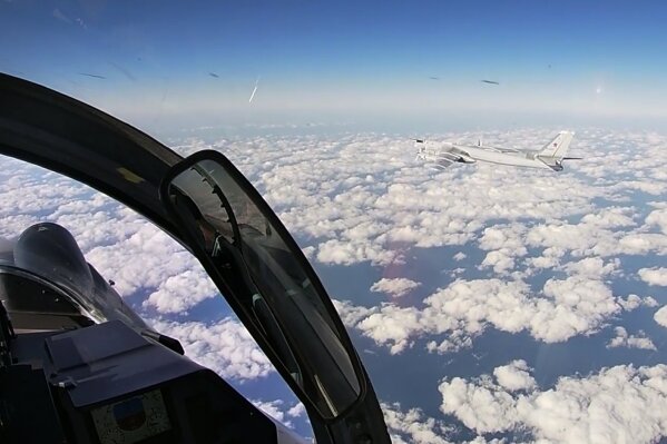 In this photo taken from a video distributed by Russian Defense Ministry Press Service, on Tuesday, Dec. 22, 2020, a Russian Tu-95 strategic bomber flies during a joint patrol mission over the Western Pacific. Russian and Chinese bombers flew a joint patrol mission over the Western Pacific Tuesday in a show of increasingly close military ties between Moscow and Beijing. The Russian military said that a pair of its Tu-95 strategic bombers and four Chinese H-6K bombers flew over the Sea of Japan and the East China Sea. (Russian Defense Ministry Press Service via AP)
