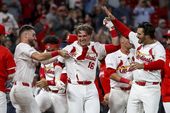 St. Louis Cardinals' Nolan Gorman, center, is mobbed by teammates as they celebrate after his walkoff home run during the ninth inning of a baseball game against the Arizona Diamondbacks, Monday, April 22, 2024, in St. Louis. (AP Photo/Scott Kane)