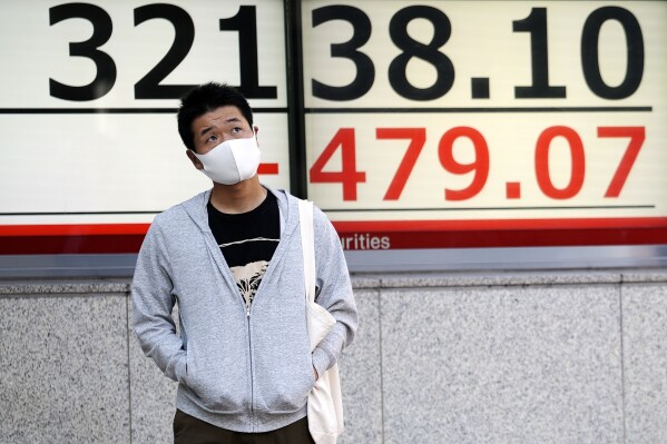 A person stands in front of an electronic stock board showing Japan's Nikkei 225 index at a securities firm Tuesday, Oct. 17, 2023, in Tokyo. Asian shares advanced Tuesday after U.S. stocks rallied as investors unwound some of last week’s moves driven by worries about war in the Middle East. (AP Photo/Eugene Hoshiko)