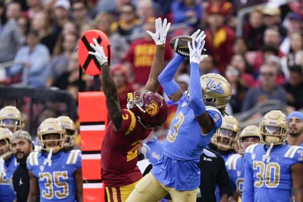 UCLA defensive back Devin Kirkwood, right, intercepts a pass intended for Southern California wide receiver Brenden Rice during the first half of an NCAA college football game, Saturday, Nov. 18, 2023, in Los Angeles. (AP Photo/Ryan Sun)