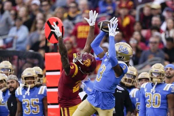 UCLA defensive back Devin Kirkwood, right, intercepts a pass intended for Southern California wide receiver Brenden Rice during the first half of an NCAA college football game, Saturday, Nov. 18, 2023, in Los Angeles. (AP Photo/Ryan Sun)