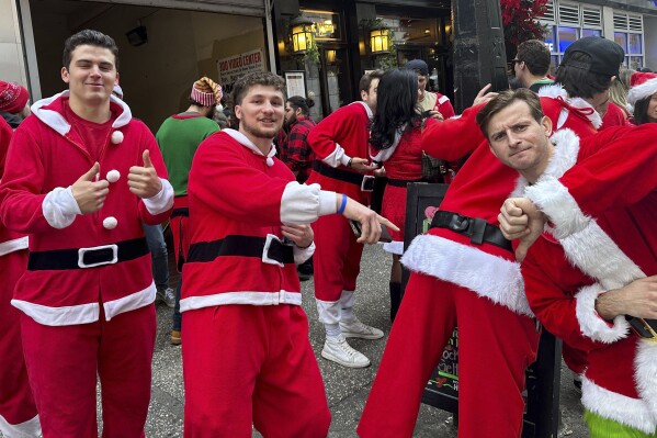 Revelers take part in the annual SantaCon charity pub crawl on Saturday, Dec. 9, 2023 in New York. Thousands of people dressed as jolly Old St. Nick have descended on New York City that kicked off early Saturday morning in bars in midtown Manhattan. (AP Photo/Andrew Meldrum)