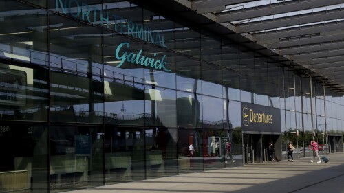 FILE - Passengers walk into the Departures entrance at the North Terminal of Gatwick Airport near Crawley, just south of London, Wednesday, July 22, 2020. Hundreds of thousands of British vacationers face potential disruption to their travel plans at the start of the school summer holidays, after almost 1,000 workers at London’s Gatwick Airport voted to strike in a dispute over pay. The Unite union said Friday, July 14, 2023, that members, including baggage handlers and check-in staff, who are employed by four private contractors will walk out for four days from July 28 and again for a subsequent four-day stretch from Aug. 4. (AP Photo/Matt Dunham, File)