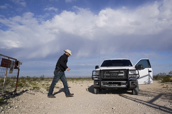 Terrell County Sheriff Thaddeus Cleveland walks to his truck after opening a gate leading to Bone Water Crossing on the Rio Grande River, Thursday, March 21, 2024, in Terrell County, Texas. (AP Photo/Erik Verduzco)