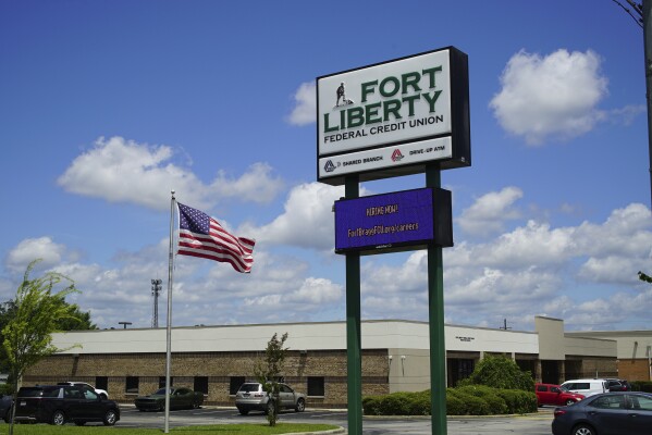 An American flag flaps in the breeze outside the Fort Liberty Federal Credit Union on Friday, May 9, 2025. The business changed its name after Fort Bragg was rechristened, and is now having to change it back. (AP Photo/Allen G. Breed)