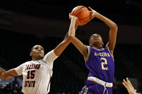 Jackson State guard Angel Jackson (15) blocks a shot-attempt by Alcorn State guard Nakia Cheatham (2) during the first half of an NCAA college basketball game in the championship of the Southwestern Athletic Conference tournament, Saturday, March 16, 2024, in Birmingham, Ala. (AP Photo/Butch Dill)