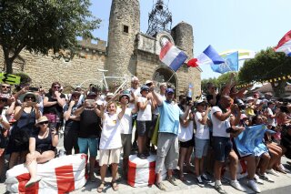 Spectators hold French flag during the seventeenth stage of the Tour de France cycling race over 200 kilometers (124,27 miles) with start in Pont Du Gard and finish in Gap, France, Wednesday, July 24, 2019. (AP Photo/Thibault Camus)