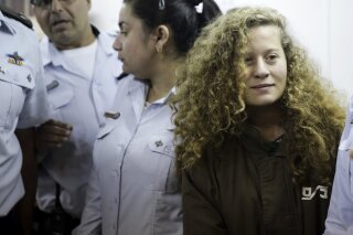 
              FILE - In this Dec. 28, 2017 file photo, Ahed Tamimi is brought to a courtroom inside Ofer military prison near Jerusalem. A senior Israeli official on Wednesday said he led a secret investigation into 16-year-old Palestinian protest icon Ahed Tamimi and her family, in part because their appearance, including "blond-haired, freckled" children in “Western clothes,” made them seem less like “real” Palestinians. (AP Photo/Mahmoud Illean, File)
            