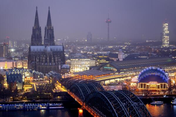 The illuminated city center with the Cathedral in Cologne, Germany, Tuesday, Nov. 29, 2022. An unprecedented crisis of confidence is shaking the Archdiocese of Cologne. Catholic believers have protested their deeply divisive bishop and are leaving in droves over allegations that he may have covered up clergy sexual abuse reports. (AP Photo/Michael Probst)