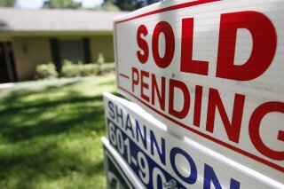 This June 13, 2019, photo shows a house with a "sold pending" sign fixed on the realtor's sign in northeast Jackson, Miss. On Friday, June 21, the National Association of Realtors reports on sales of existing homes in May. (AP Photo/Rogelio V. Solis)